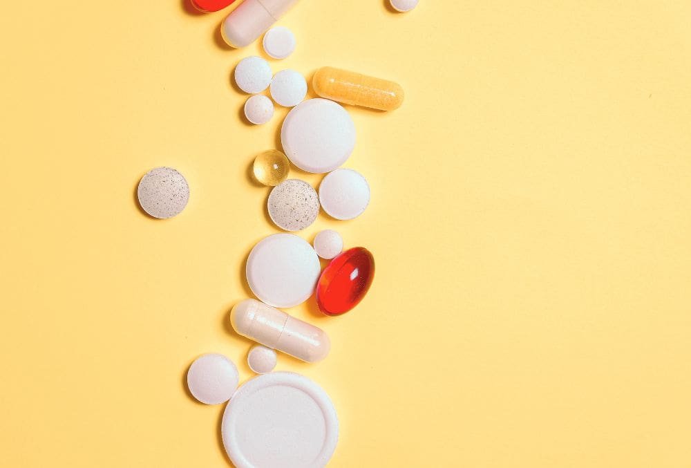 an image of prescription pills on a yellow background indicating the negative impact of the abuse of prescription drugs and how that can lead to substance abuse.